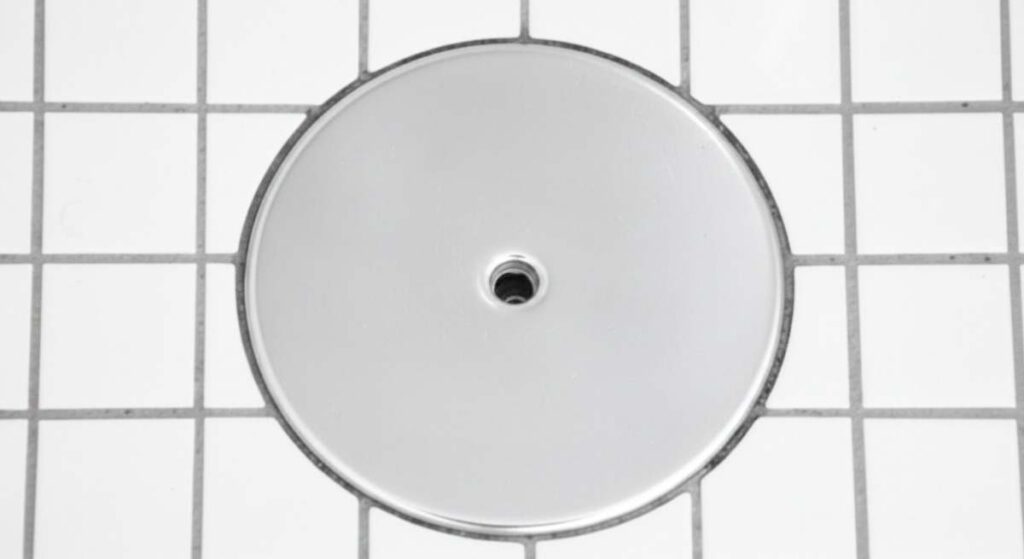 Qué es la tapa redonda y plateada del suelo del baño y qué función tiene