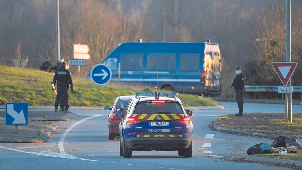 Vehículos de la policía francesa, en una carretera.