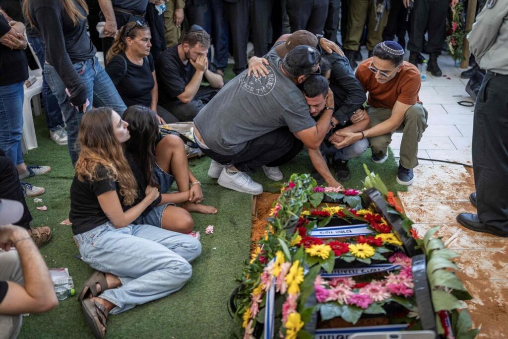 Relatives and family members mourn at the grave of Israeli army Major Yuval Ezra, 27, killed in the Israeli-occupied Palestinian West Bank, during his funeral in Bet Dagan, central Israel on July 26, 2026. The Israeli military said on June 24, 2026, that a second Israeli, Yuval Ezra, had been killed during a violent confrontation between Israelis and Palestinians in the area of the village of Tell in the Israeli-occupied West Bank. The occupied West Bank has been gripped by almost daily violence involving Israeli troops and settlers since the start of the Gaza war in October 2023. (Photo by ilia YEFIMOVICH / AFP)